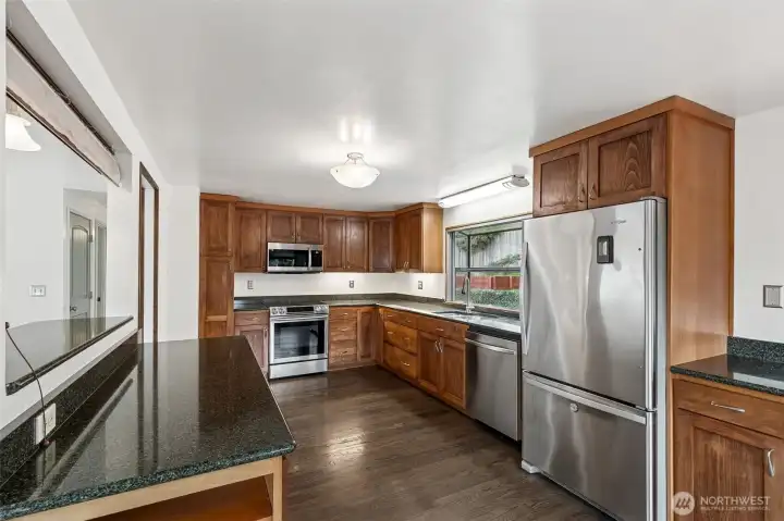 Open Concept Kitchen: Remodeled kitchen with an integrated eating bar, sleek cabinetry, and a seamless flow into the dining and living areas