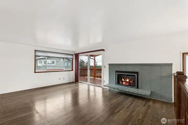 Living Room: Bright and airy living space featuring a gas fireplace and oversized sliding glass doors that perfectly frame the puget sound and territorial views.