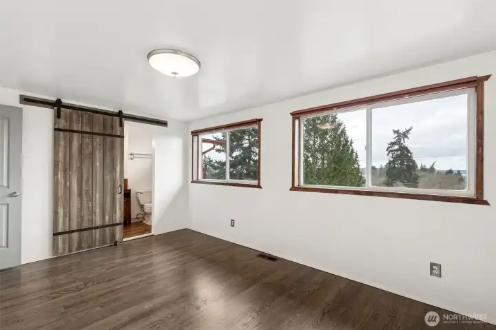 Primary Suite: Spacious primary suite on the main floor, thoughtfully updated for comfort and maximum natural light.