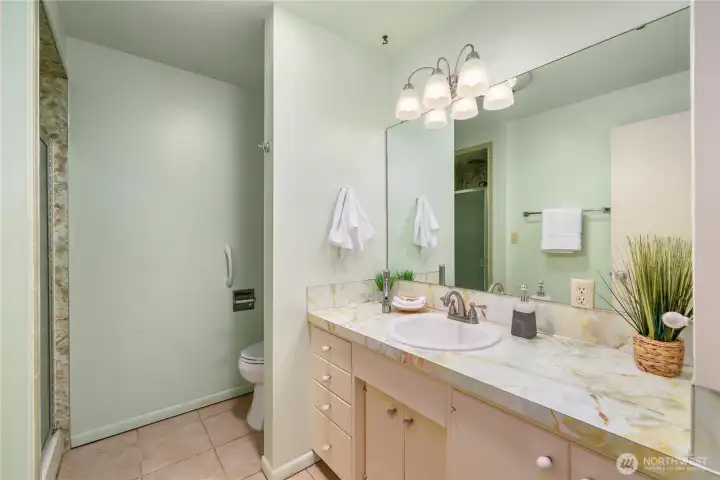Primary bath has a long vanity with plenty of storage underneath.