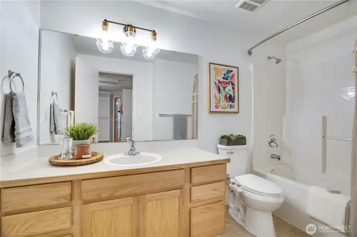 The primary suite's full bath offers a shower/tub and a large vanity with plenty of storage space. The primary suite's full bath offers a shower/tub and a large vanity with plenty of storage space.