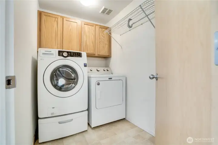 The laundry room includes this washer and dryer. Store detergent and cleaning supplies in the cabinets, and hang delicates from the rack to air dry. The laundry room includes this washer and dryer. Store detergent and cleaning supplies in the cabinets, and hang delicates from the rack to air dry.