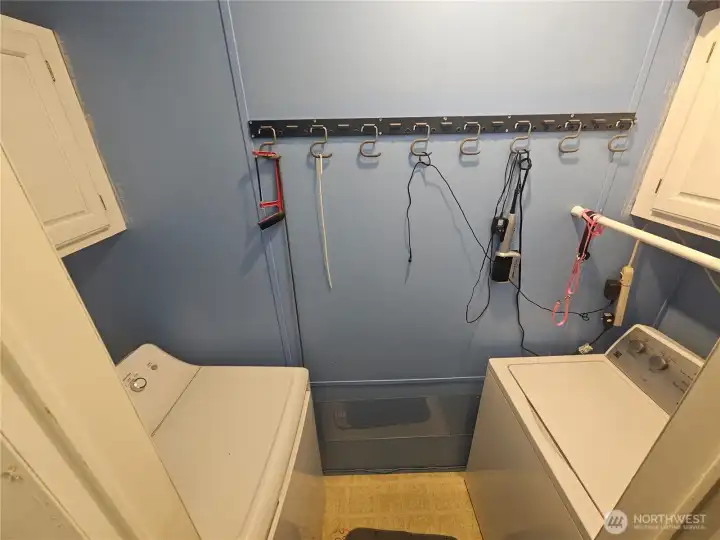 Utility room with cupboards above each appliance. Utility room with cupboards above each appliance.