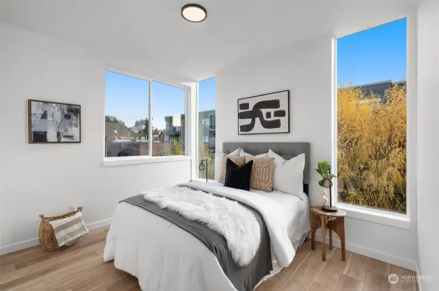 Wake up to serene views from this secondary bedroom, featuring floor-to-ceiling windows and ample natural light. It is a perfect sanctuary to start and end your day.