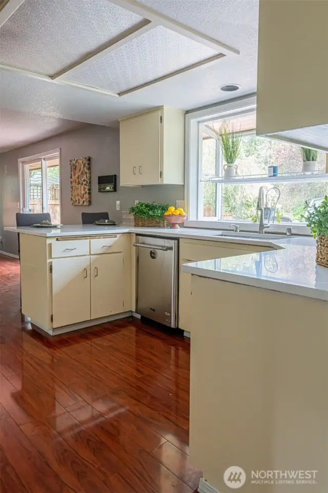 Kitchen with breakfast bar has a wonderful window overlooking hte park like backyard