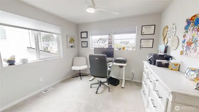 Bedroom with walk in closet with windows facing both the front and side of home for plenty of natural lighting.