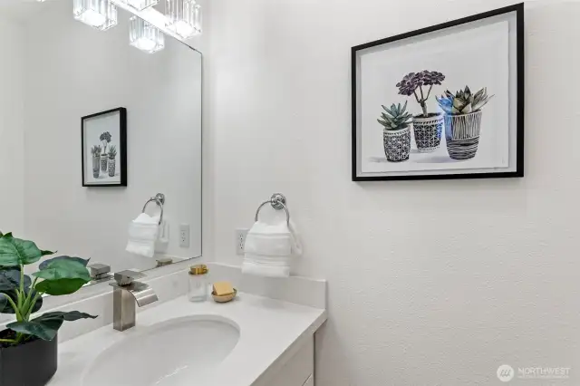 A convenient remodeled powder room on the main floor features crushed quarts counter, a painted white vanity and hardwood floors.