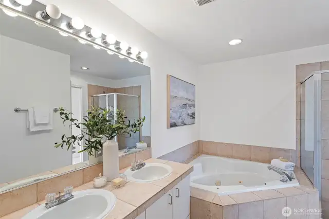 The 5-piece primary en-suite bathroom features a large jetted soaking tub, separate shower and double vanity.