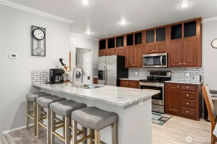 The granite peninsula with seating for four creates an easy, everyday spot for meals, coffee, or catching up while cooking.