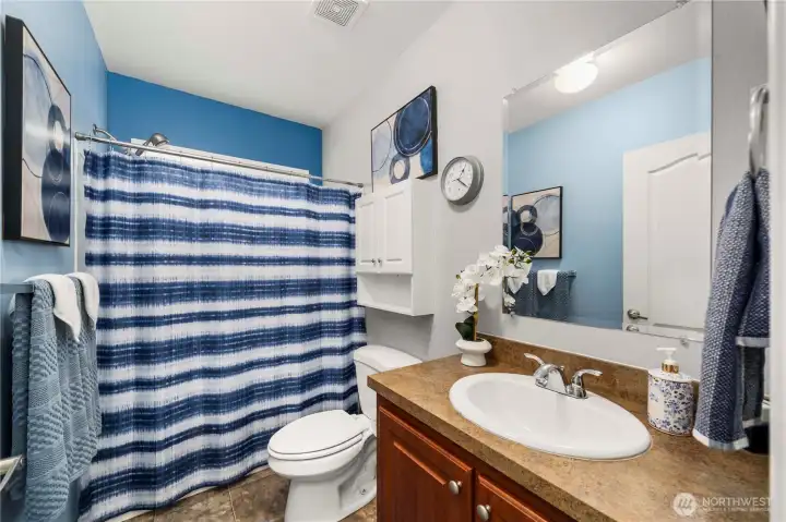 The guest bathroom features a shower/tub combo and tons of storage, offering a practical and comfortable setup for everyday use or visitors.