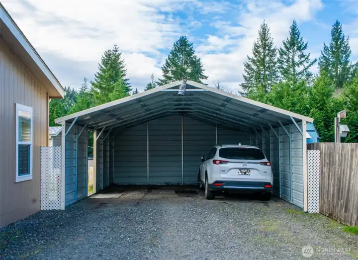 A sturdy metal carport provides covered parking and everyday protection for vehicles, with easy access to the home.
