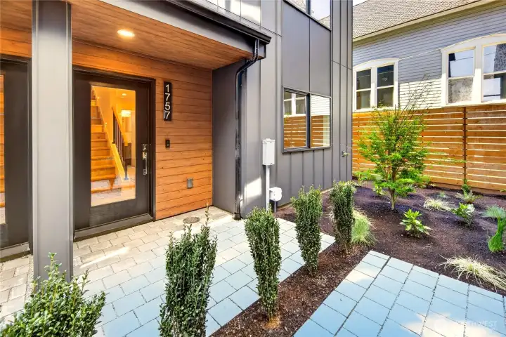 Enter through a landscaped courtyard to your covered front porch
