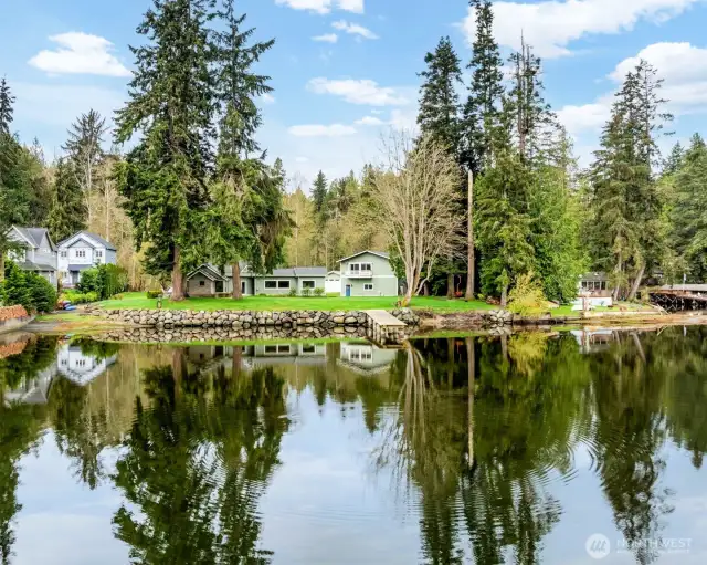 The property boasts a stunning waterfront view, featuring a newly installed bulkhead, a dock that extends over 75 feet, and a convenient boat ramp perfect for launching your kayak or fishing boat