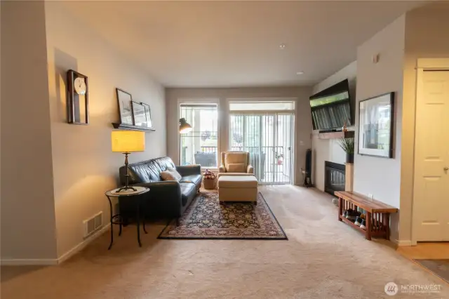 Bright and inviting living room featuring a cozy gas fireplace and seamless access to the private balcony—perfect for relaxing or entertaining.