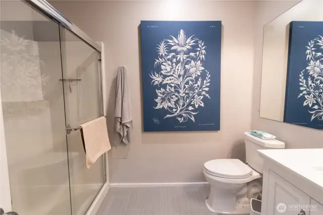 Cozy and functional main 3/4 bathroom featuring a modern walk-in shower, updated fixtures, and warm finishes. Ideal for everyday convenience or hosting guests, this bathroom offers comfort and efficiency with a welcoming style. Perfectly designed to maximize space while maintaining a relaxing, home-like feel.