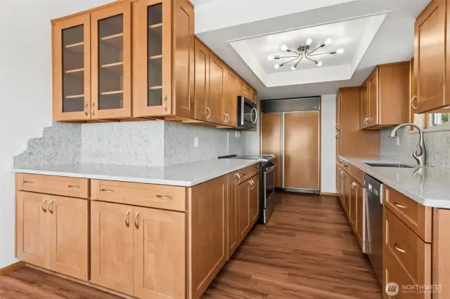 Completely renovated kitchen with quartz countertops, ample storage, and stylish lighting.