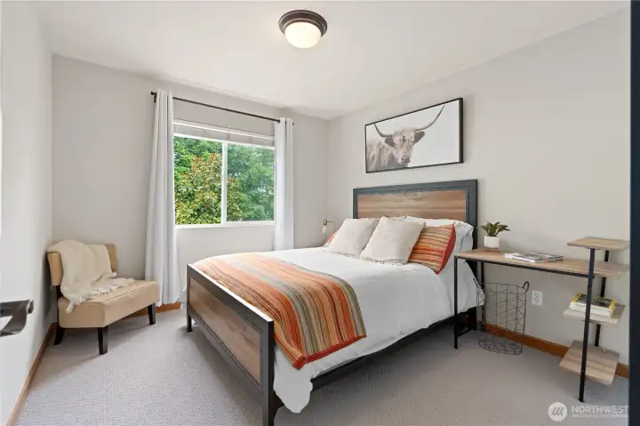 This bedroom features a large window, making it ideal for a home office or guest room.