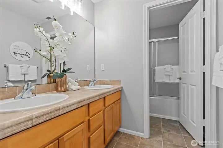 Guest bathroom with double sinks - separate toilet and tub/shower space.