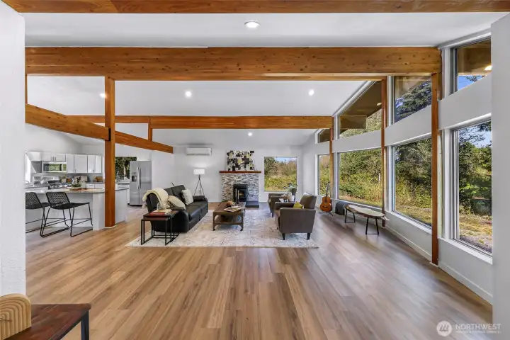 High vaulted ceiling with gleaming wood beams - foward towards the rock and wood mantel surrounding the pellet stove.