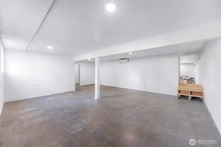 From the main side lower level entry - there is a very large living room area.  Doorway in the middle leads to a large storage and mechanical room for the home.  Stairs lead to the rest of the lower level.  To the left of stairs is the staircase that leads to the upper level.