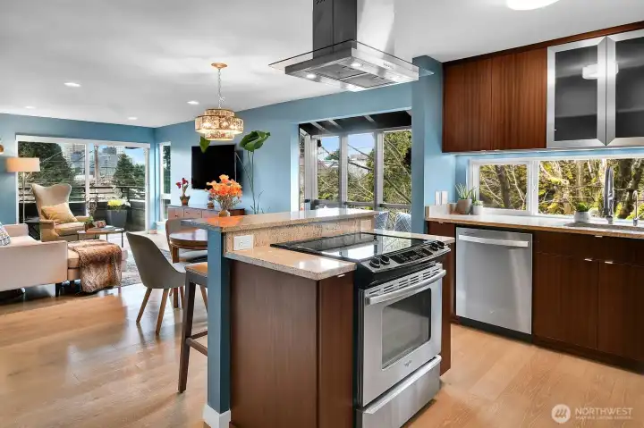 Social kitchen design includes an outward-facing island cooktop with breakfast bar.