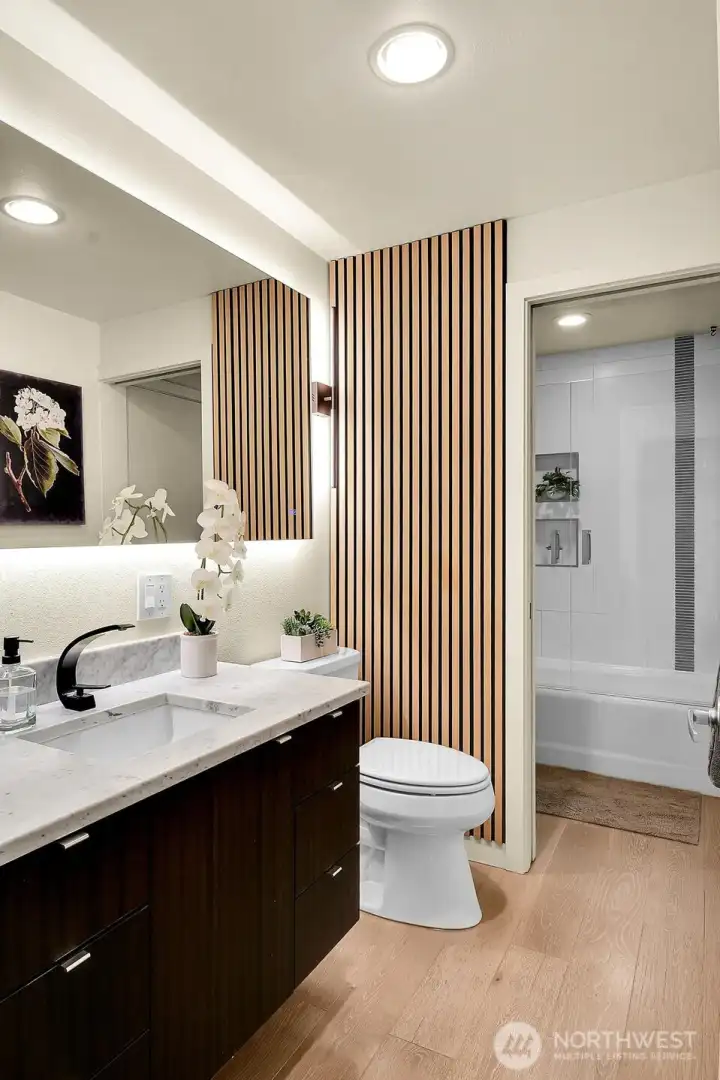 Updated "continental" bath, meaning it's accessible from both the hallway & primary bedroom.