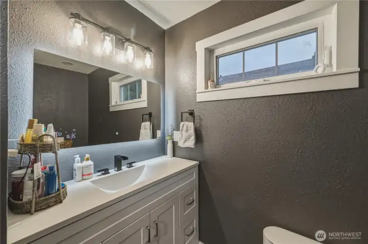 Bathroom updated with new vanity; light fixture, tile floors and fresh paint.