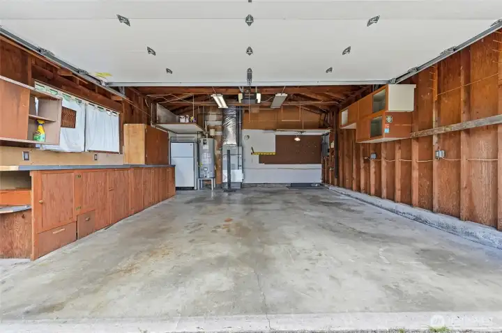 2 car garage with electric garage door opener and workshop or storage cabinetry.