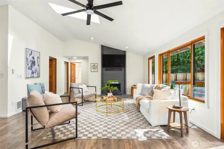 Spacious living room with vaulted ceilings, oversized windows, and abundant natural light.
