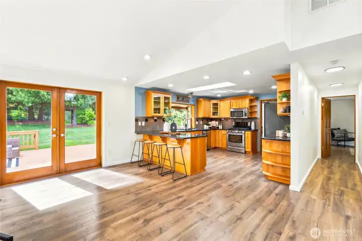 Open-concept kitchen with granite countertops, stainless steel appliances, abundant cabinetry, and an eating bar for casual dining.