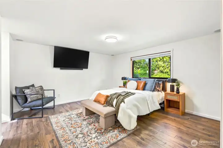 Spacious primary suite featuring fresh interior paint, new laminate flooring, and plenty of room for a sitting area or workspace.