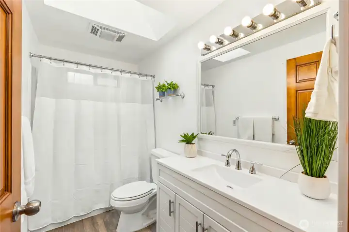 Completely renovated bathroom (2026) featuring a new vanity, updated fixtures, modern finishes, and a skylight for abundant natural light.