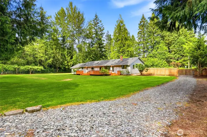 Extended gravel driveway leads to a large, level parking area ideal for RVs, boats, equipment, or future shop potential.