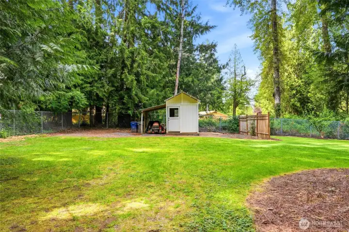 Sprawling backyard offers exceptional privacy, mature landscaping, and additional storage with a detached shed and covered storage area.