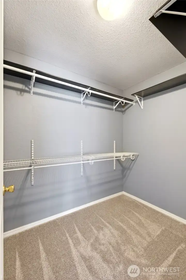Walk in closet in primary bedroom.