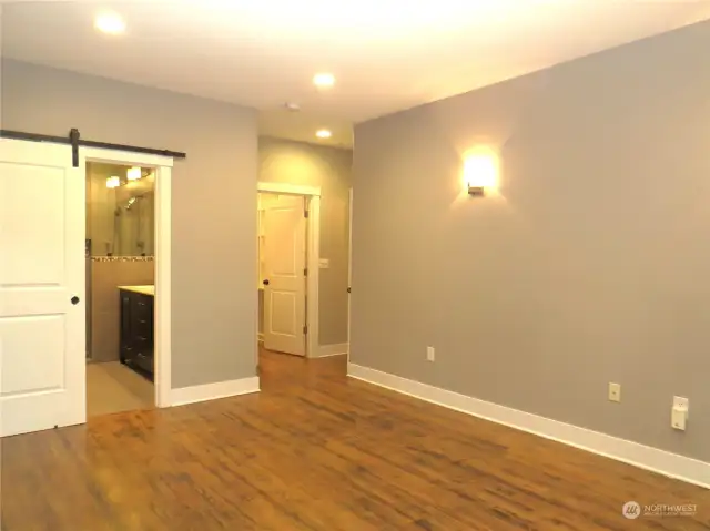 VIEW OF THE PRIMARY BEDROOM WALK-IN CLOSET AND SLIDING BARN DOOR ENTRY TO THE BATHROOM!