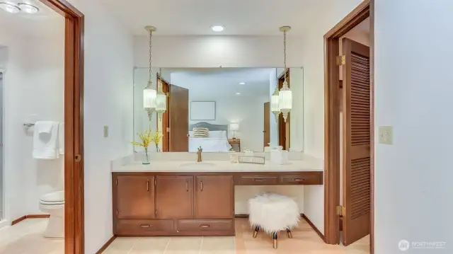 Functional vanity corner offering easy access to both the walk-in closet and the bathroom.