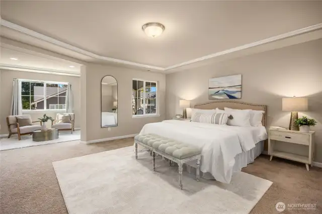 The spacious primary suite with a sitting area and private balcony.