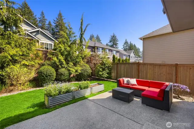 The backyard is fenced with nice grassy play space and sunny garden beds.