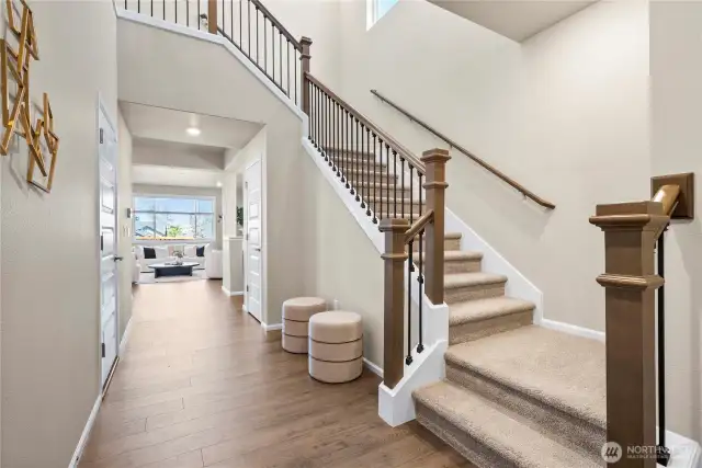 Grand foyer highlighted with modern iron open railing. Perfect for holiday decor!