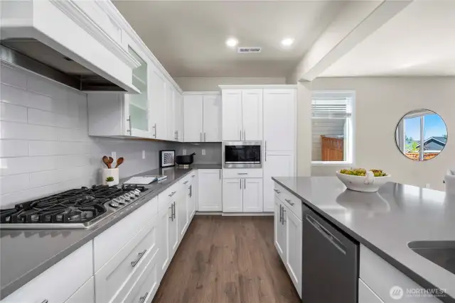 Built in gas range & microwave. With luxury boxed in hood vent and shadow box cabinets.