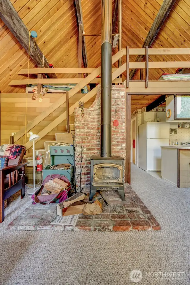 Wood stove main level and hallway leading to bedroom and bathroom.