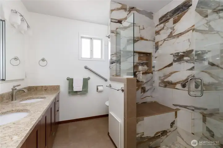 Primary bath features a large shower with seat.