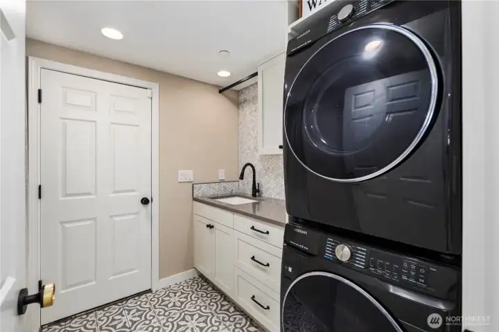 Laundry room with sink and storage space.