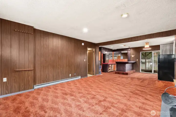Rec room has plenty of room for a pool table. (We tested it!) and bar with retro audio system is set up.  Note sliding glass door with convenient patio entry.
