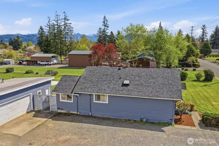 The side of the home showcases the clean lines of the new roof and provides convenient, level access to the expansive yard and detached shop.