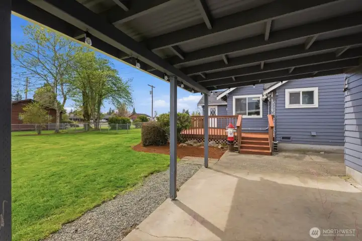 The side covered patio offers a protected, year-round space for outdoor projects or a shaded spot to relax regardless of the weather.