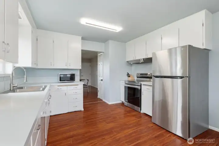 Modern Efficiency: The kitchen features newer stainless steel appliances and a deep-basin sink, blending everyday functionality with a clean, updated look.