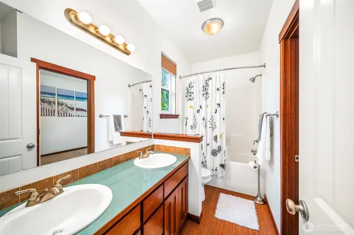 Double sink vanity with full tub and shower.