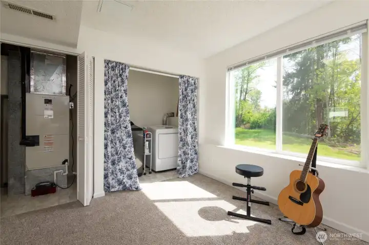 Bright Family Room/Rec Room with a neatly Electric Washer/Dryer space and Electric HVAC room is behind stylish barn doors